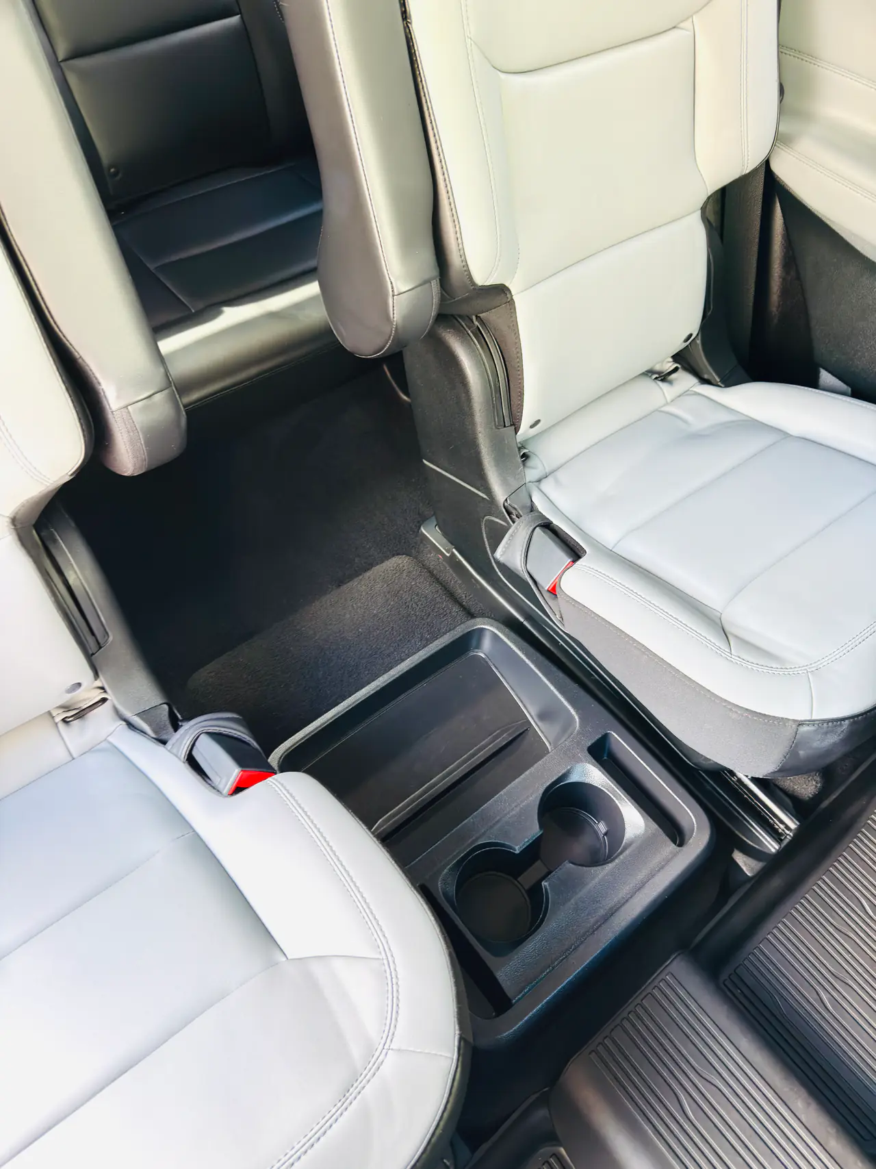 After an interior detail: the same SUV second row with clean leather seats, console and carpet