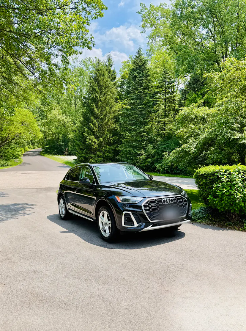 Black Audi Q5 after an exterior detail on a tree-lined driveway