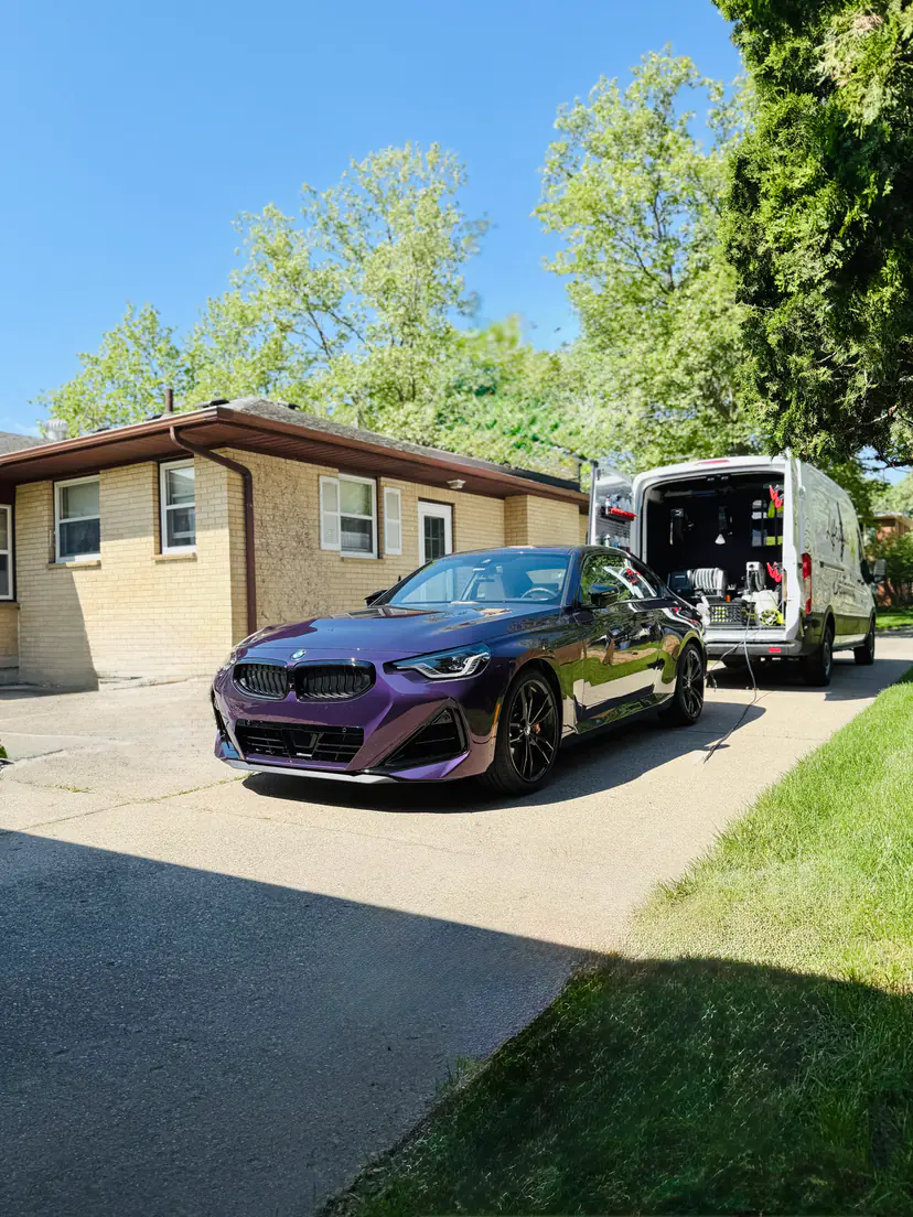 Purple BMW M2 coupe after a detail, the Lifestyle Detailing van's mobile setup open behind it