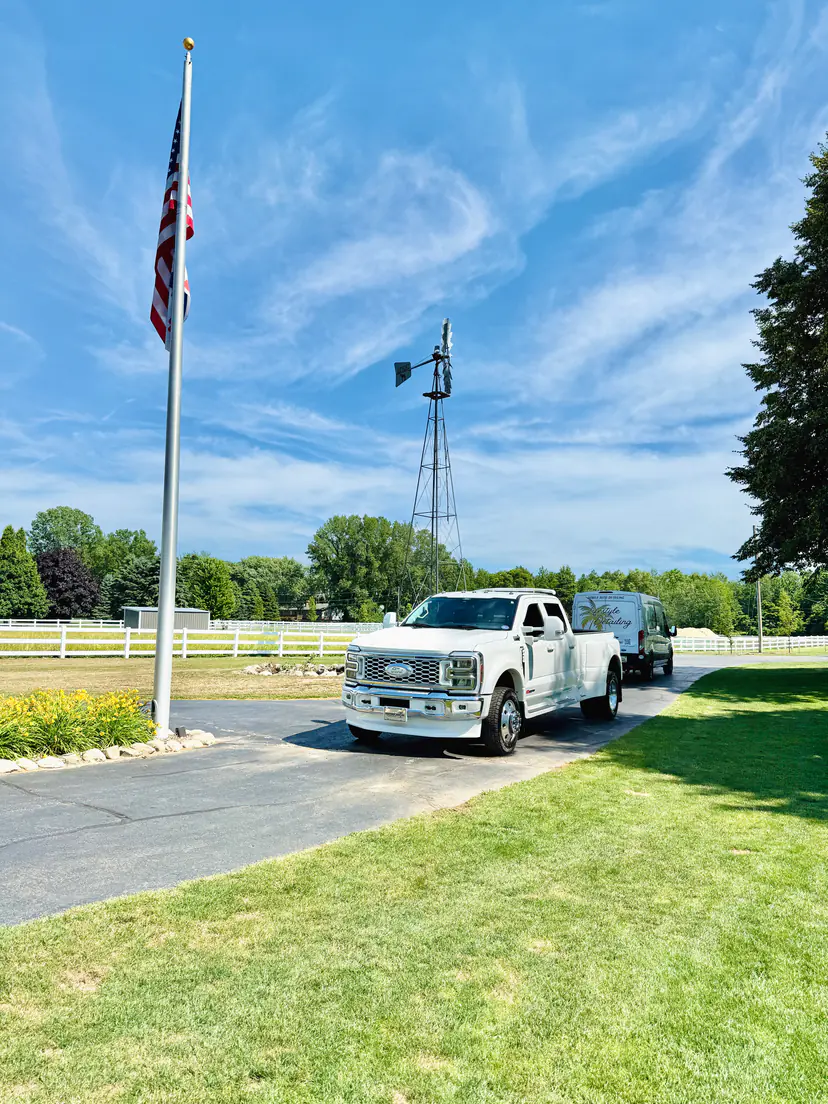 White Ford F-450 dually after a detail on a farm drive in Laketown Township, Michigan, a flagpole and a windmill behind it