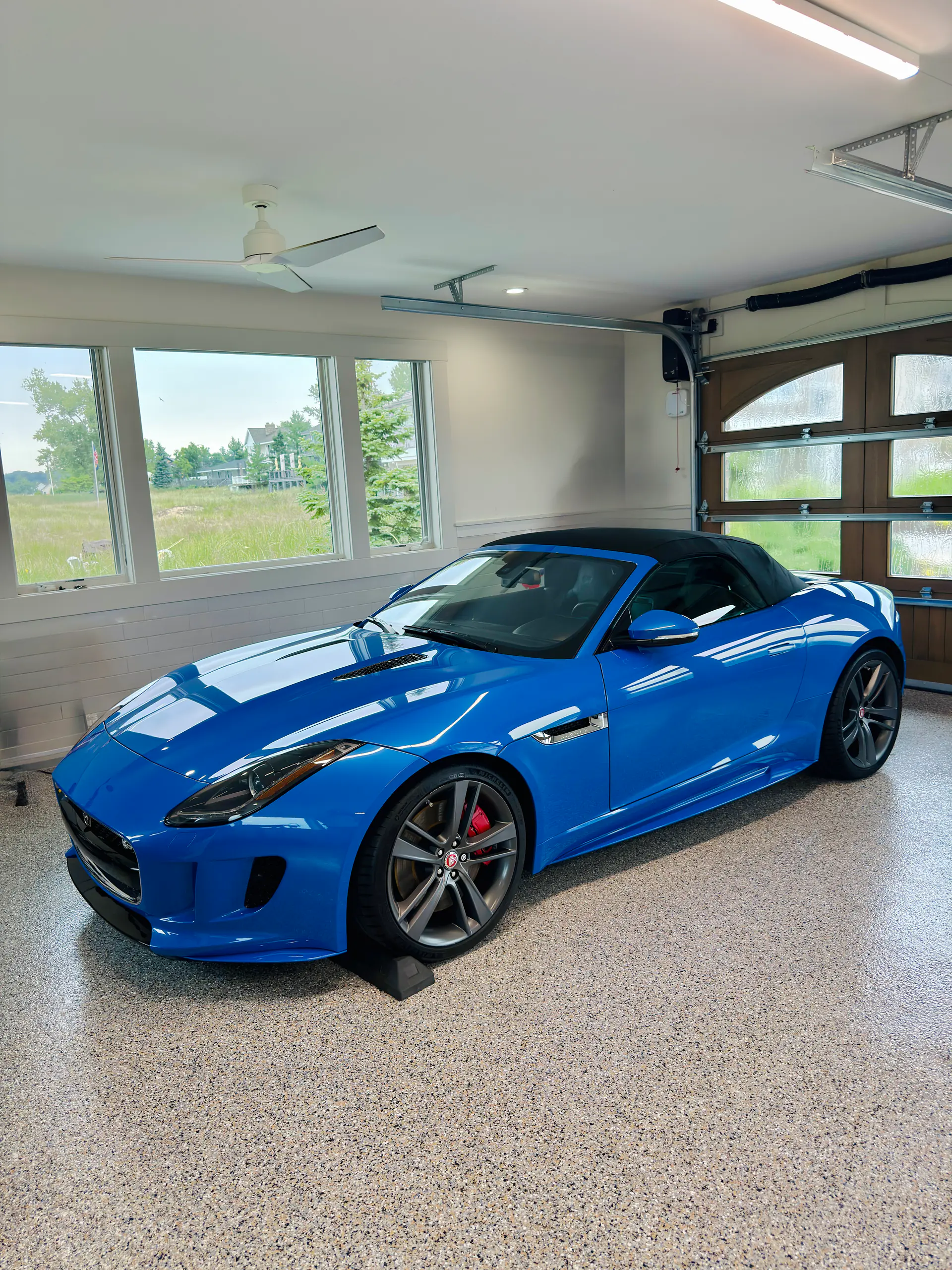 Ceramic-coated blue Jaguar F-Type parked in a spotless epoxy-floored garage