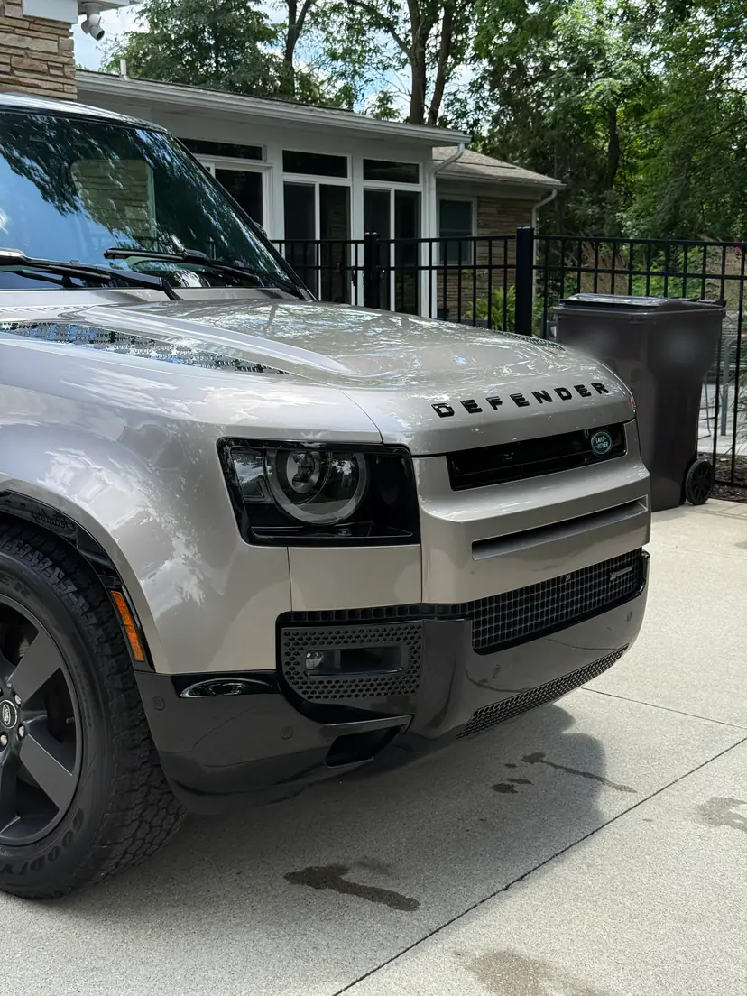 Close view of a Land Rover Defender's glossy hood and grille after an exterior detail in Grand Rapids Township, Michigan