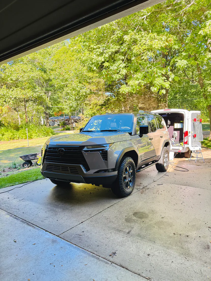 Grey Lexus GX after a detail, seen from under a garage eave with the Lifestyle Detailing van behind