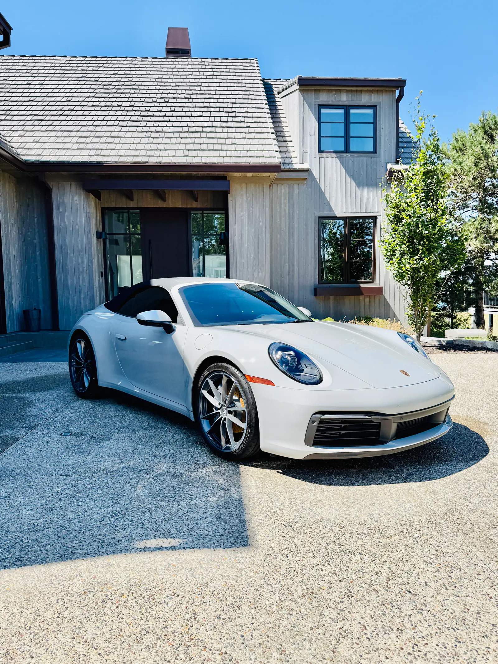 Ceramic-coated white Porsche 911 Cabriolet in front of a modern farmhouse