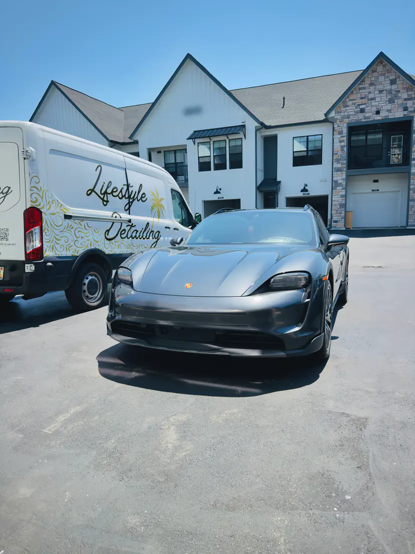 Porsche Taycan with a glossy finish after a detail, parked beside the Lifestyle Detailing van
