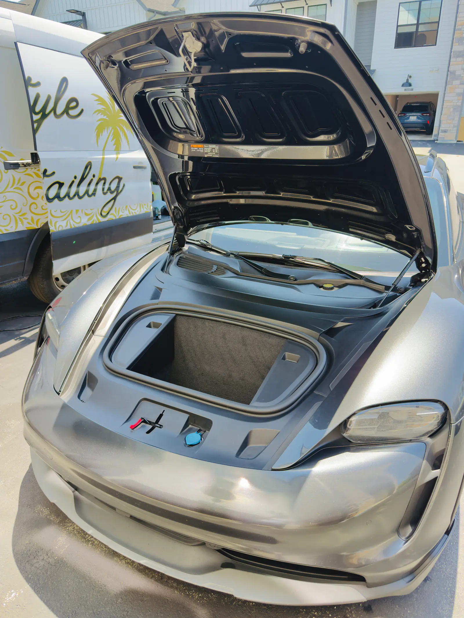 Porsche Taycan with its front trunk open, cleaned and detailed