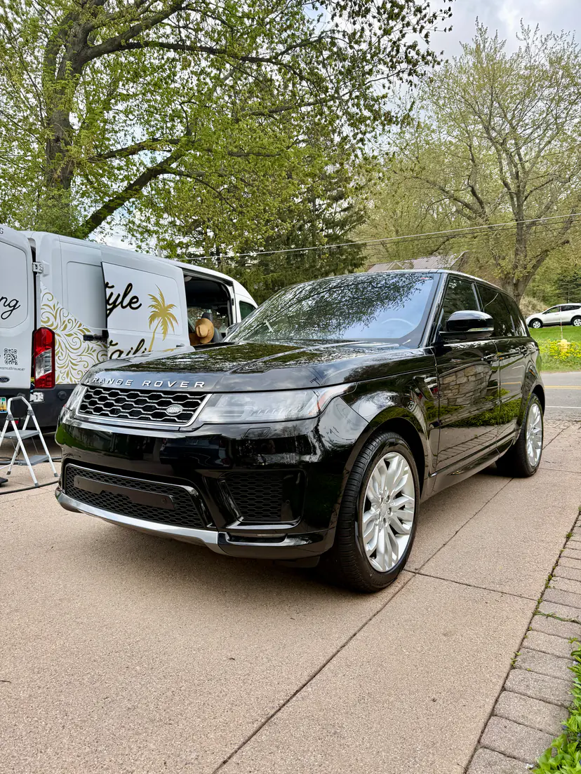 Black Range Rover Sport after a mobile detail, seen low beside the Lifestyle Detailing van with its doors open