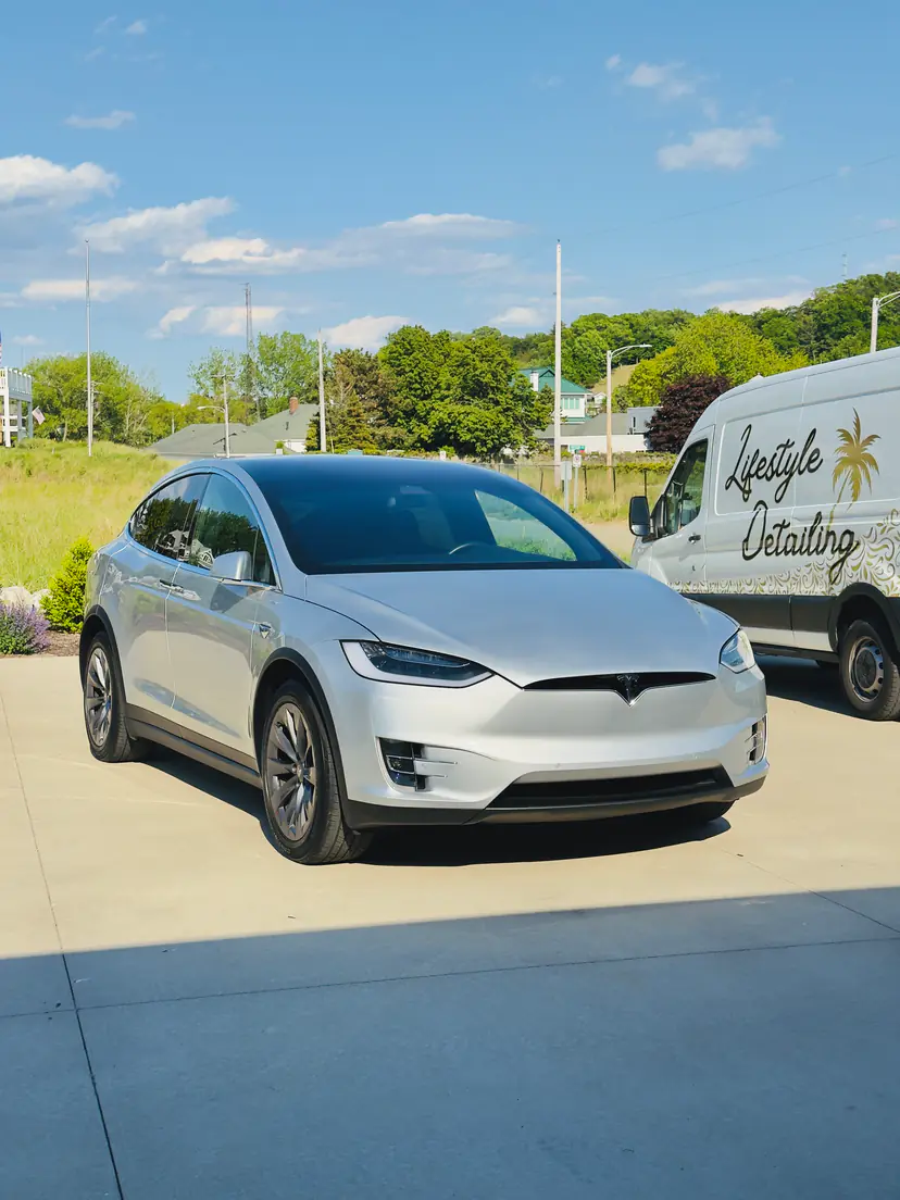 Silver Tesla Model X after an exterior detail beside the Lifestyle Detailing van