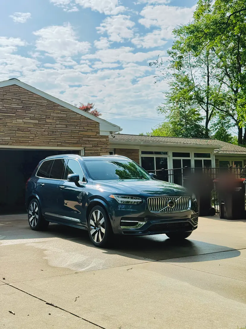 Dark blue Volvo XC90 after an exterior detail in front of a stone ranch home