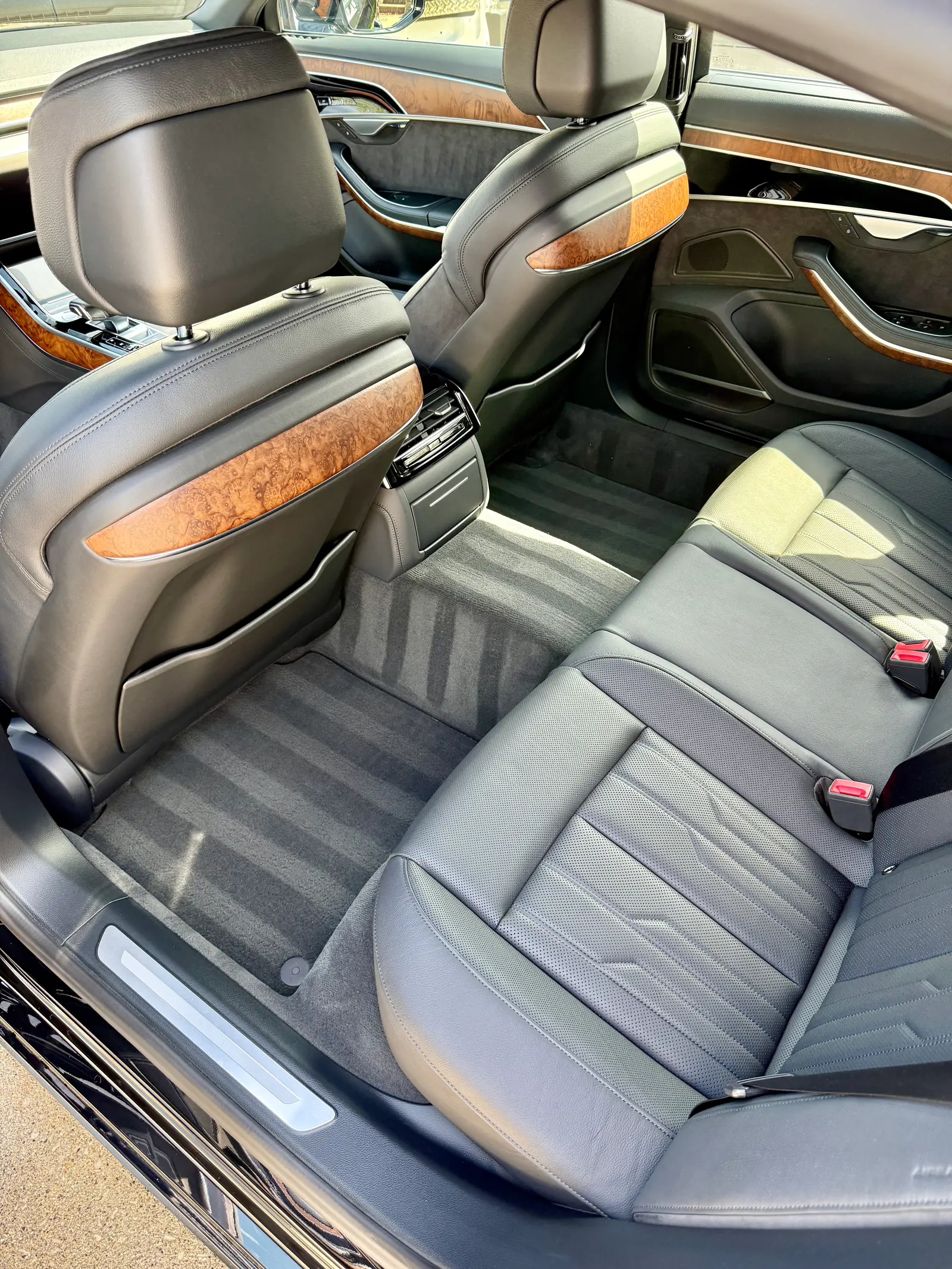 Audi A8 L rear cabin with spotless leather seats, walnut trim and fresh vacuum lines after an interior detail