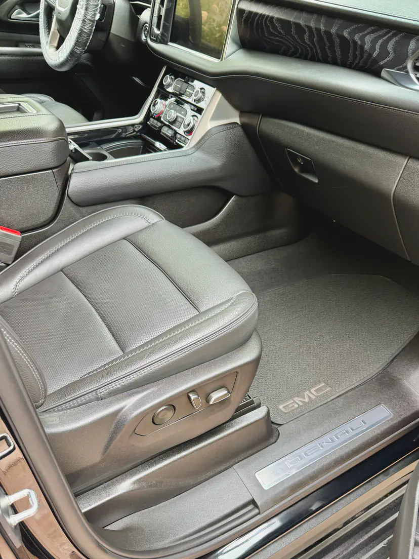 GMC Yukon Denali front passenger seat in black leather after a mobile interior detail, the Denali sill plate in view