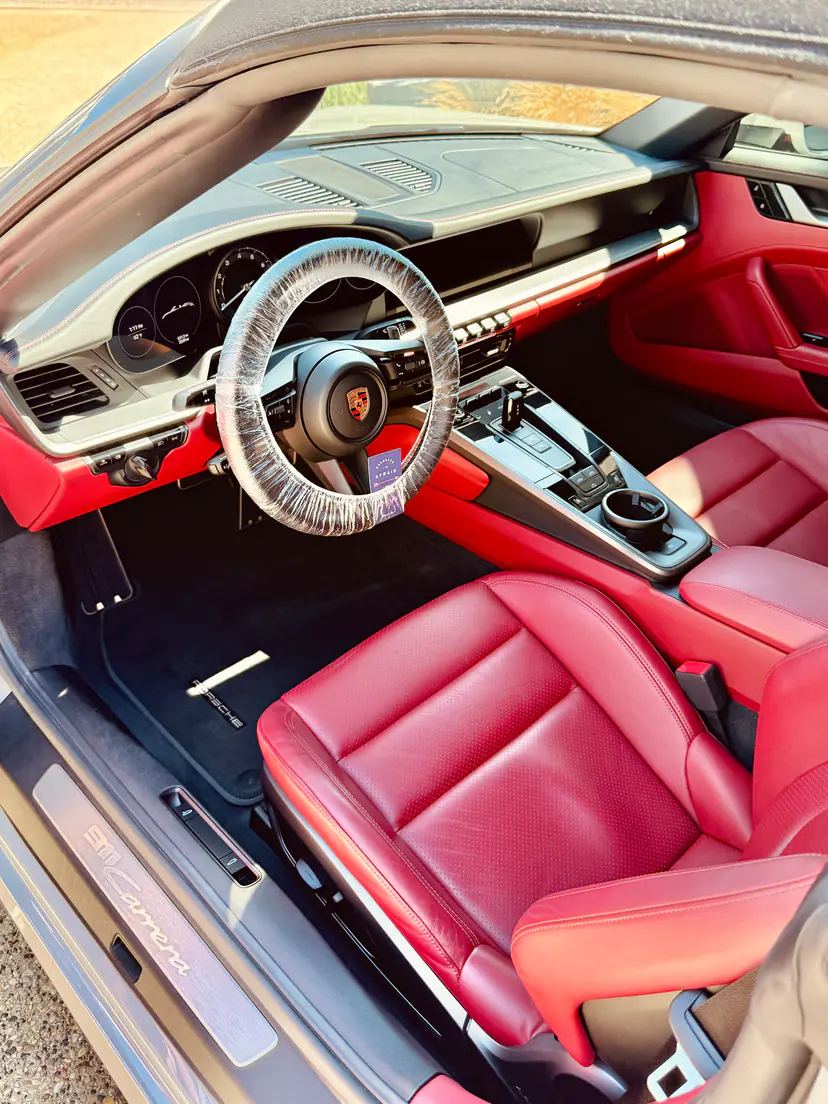 Porsche 911 cabin with Bordeaux-red leather seats cleaned and conditioned during an interior detail
